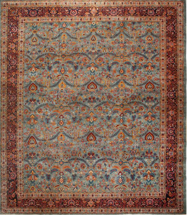 Square rug with a blue-green field and dense, colorful traditional floral patterns and multi-layered red borders.
