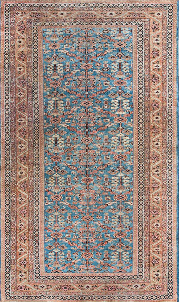 A rectangular runner rug features a teal blue central field with geometric rust and cream motifs, surrounded by a wide peach border.