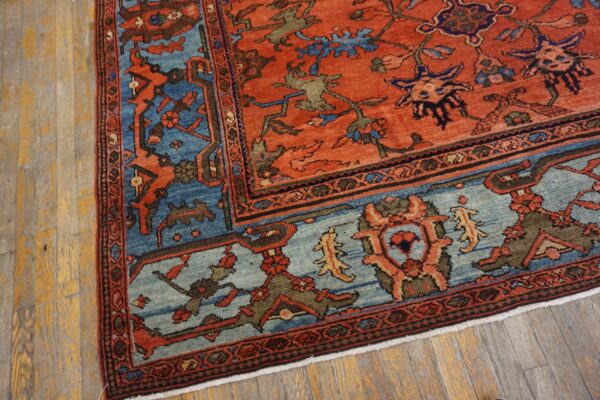 Red-orange patterned rug with blue borders visible on heavily textured wood flooring.