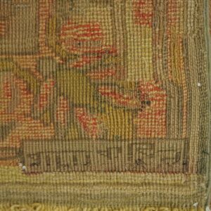 Close-up shows a rustic, ribbed rug texture with muted brown, yellow, and red geometric patterns and fringe.