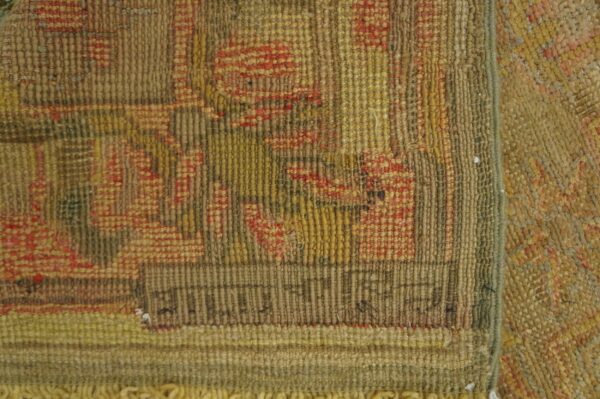 Antique oversized oushak turkish medallion knotted rug 7 Close-up shows a rustic, ribbed rug texture with muted brown, yellow, and red geometric patterns and fringe.