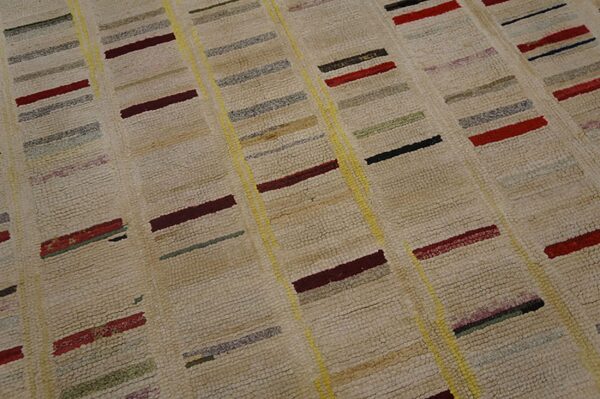 Cream shag rug detail showing vertical yellow lines and maroon, red, black, and green accent bars.