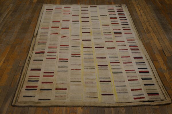 Textured cream rug featuring columns of short, colorful stripes resting on dark wood floors.