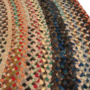 Braided rug featuring multicolored woven segments in stripes of bright and dark, earthy colors.