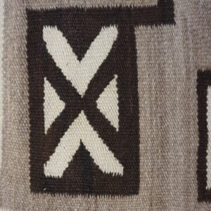 Geometric rug texture with dark brown, taupe, and cream blocks and an intersecting X-shaped design.