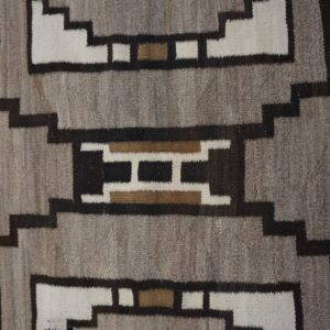 Geometric flatweave rug texture featuring stepped shapes in natural gray, white, dark brown, and tan.