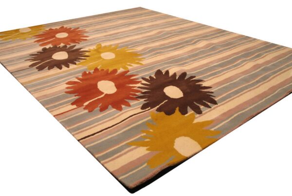 Modern rug with yellow, orange, and brown flowers layered on stripes of beige, dusty blue, and pink.