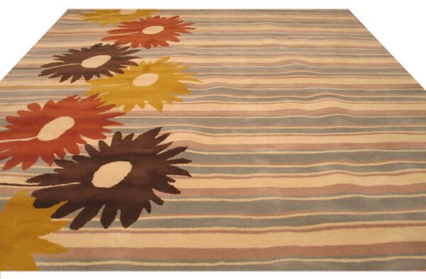 Striped rug with large dark brown, orange, and gold flowers on a cream and dusty grey ground.