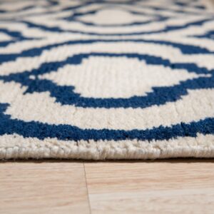 Blue and white plush rug with a geometric pattern sits close-up on light wood plank flooring.