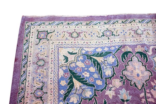 Ornate high-pile rug detail featuring floral and vine motifs in plum, light blue, cream, and deep green.
