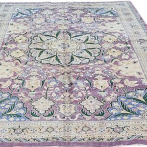 Ornate area rug with a center medallion and floral vines, colored in lavender, ivory, blue, and green.