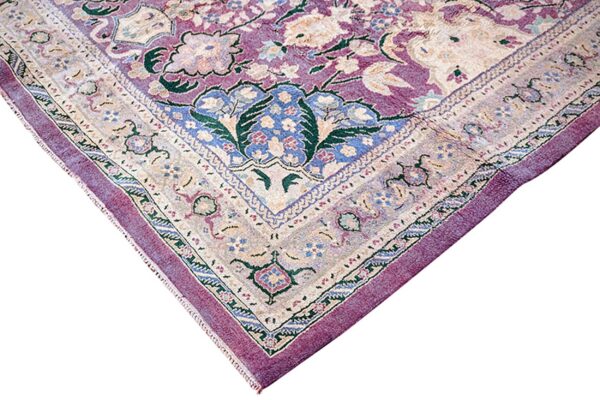 Traditional rug corner displaying faded floral patterns in mauve, cream, blue, and green against white.