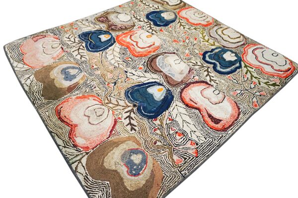 High-pile rug featuring large organic shapes in blue, coral, and brown on a dense, off-white linear ground.