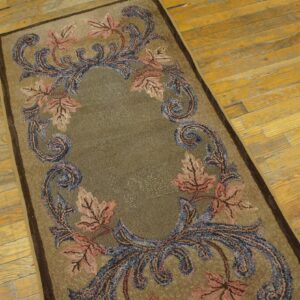Taupe runner rug with pink leaves and blue scrolling vines rests on rustic yellow hardwood planks.