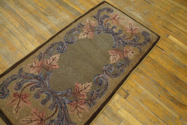 Earth-toned runner with a pink and blue botanical scroll pattern laid over worn golden hardwood.