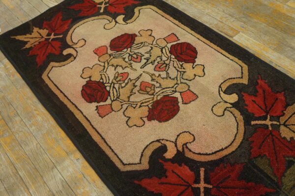 A hooked texture rug featuring red roses and tan leaves on an ivory center, surrounded by a dark brown border.