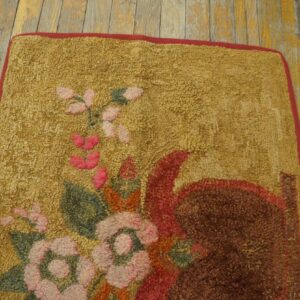 Looped gold rug featuring a dense floral pattern in pink, green, and red on distressed yellow wood floors.