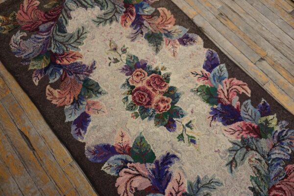 Textured rug runner features a multicolored rose and leaf design on rustic wooden floorboards.