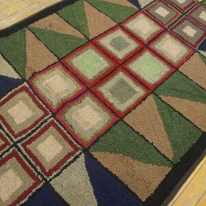 Multicolor hooked rug runner featuring bold green, red, navy, and tan geometric diamonds and triangles on wood flooring.