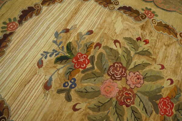 Textured low-pile rug close-up showing a dense floral bouquet of red, pink, and green on a striped beige ground.