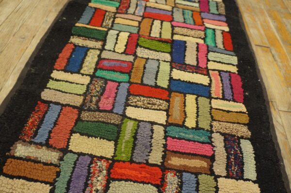 High-pile hooked rug featuring a bright, multicolored rectangular patchwork design on light wooden flooring.