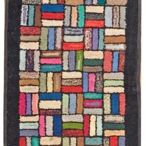 High-pile runner rug featuring a rectangular patchwork of many bright colors framed by a dark border.
