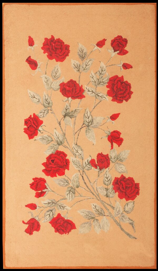 Peach-colored rug with a central floral pattern of red roses and gray leaves on a textured surface.