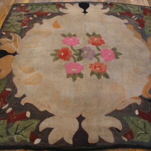 Textural rug featuring a tan floral medallion and a dark border, placed on hardwood plank flooring.