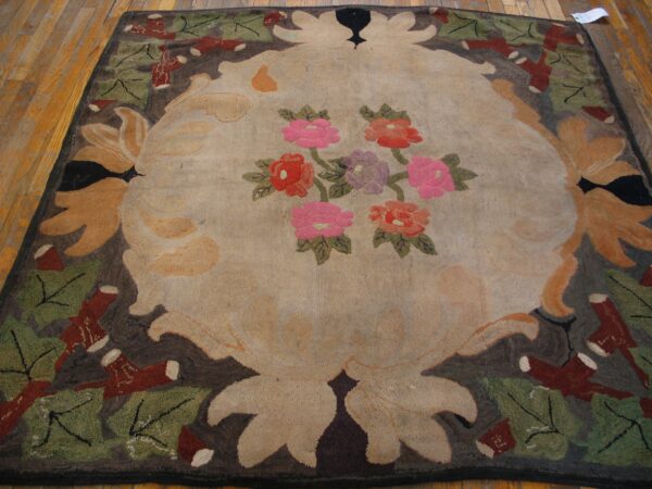 Textural rug featuring a tan floral medallion and a dark border, placed on hardwood plank flooring.