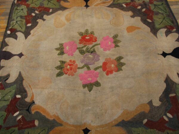 Floral rug with a beige center featuring red, pink, and purple blossoms, framed by dark and rust borders.