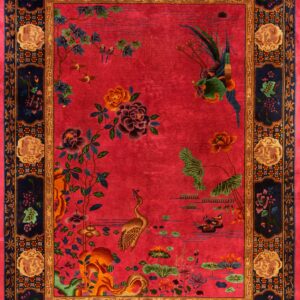 Vivid red rug with a low pile and detailed pattern of birds, flowers, and a wide dark navy border.