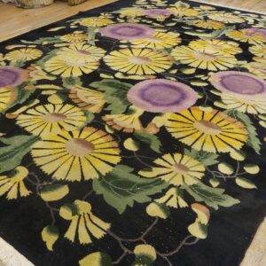 A plush, dark rug features large yellow and purple flowers with green leaves on wooden flooring.