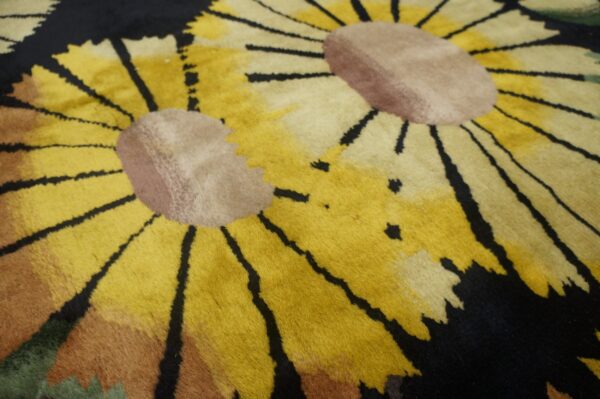 Close-up of a high-pile rug featuring yellow sunflowers, tan centers, and a black background.