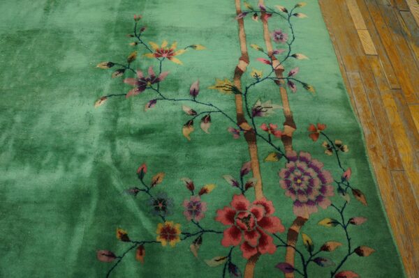 Green high-pile rug with a vibrant floral and bamboo pattern visible on distressed wooden floors.