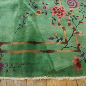 Mint green deep pile rug with floral and partial geometric patterns on worn yellow wood planks.