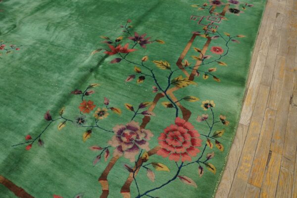 Bright green plush rug with colorful large-scale floral and branch designs on a light wooden floor.
