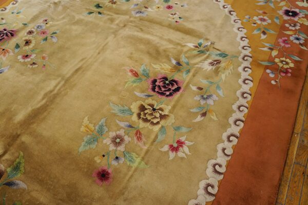 Golden rug with scattered multicolored floral bouquets and a decorative cloud border, visible over wood flooring.