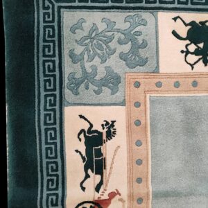 Corner detail of a plush rug featuring teal borders, Greek key design, and figurative historical motifs.
