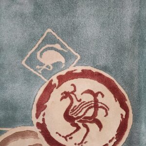 Teal rug with overlapping circles and diamonds featuring off-white and burgundy bird patterns.