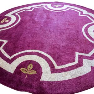A round, purple plush rug featuring an off-white decorative medallion and small gold leaf accents.