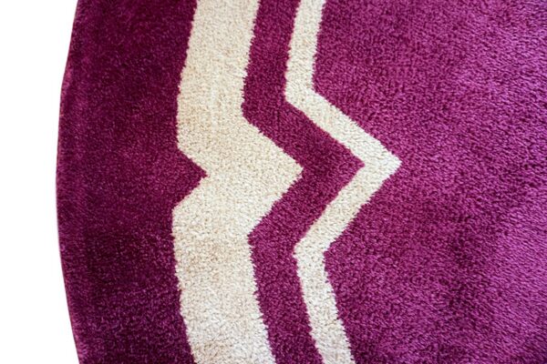 Thick shag rug detail in deep purple and cream with bold zigzag patterning.
