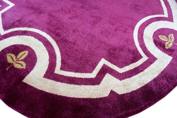 High-pile purple rug detail showing a cream scalloped border and small yellow-green leaf motifs.
