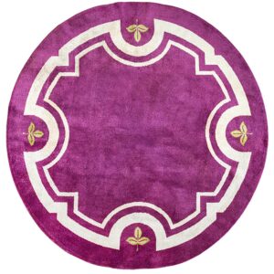 Round magenta rug featuring a creamy white geometric frame and four small green leaf motifs.