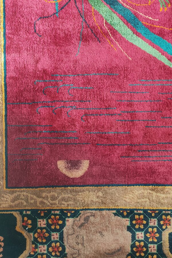 Detail shot of a magenta rug with colorful abstract lines, bordering a brown and dark geometric floral pattern.