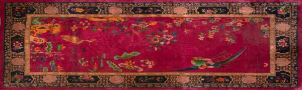 High-pile rug with a red field patterned with detailed vines, colorful flowers, and elegant birds.
