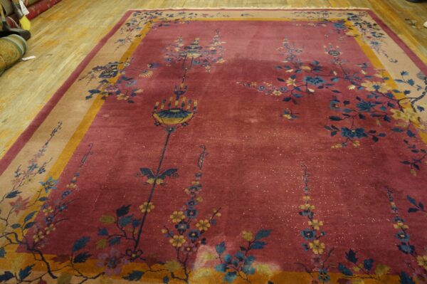 Rose rug featuring blue and yellow botanical designs, with a tan and mustard border on light wood flooring.