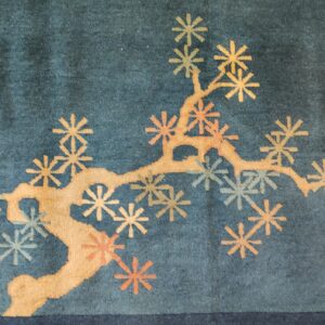 Teal rug with a stylized gold branch pattern and scattered orange and pale blue flowers.