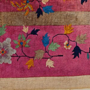 High-pile magenta rug detail with brown stripes and a flowing multicolor floral vine design.