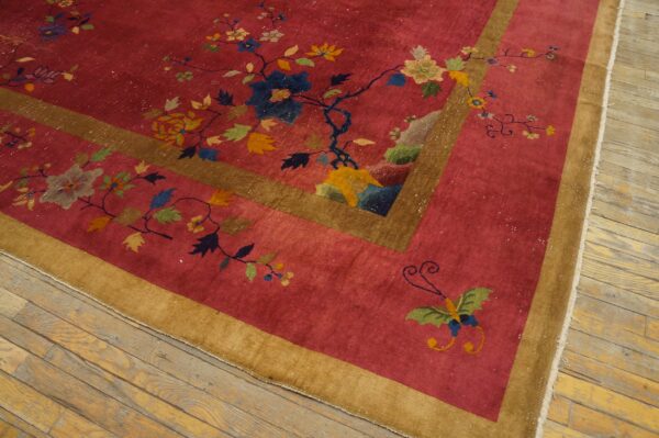 Low-pile red rug with scattered colorful florals and butterflies framed by gold borders on light wood flooring.