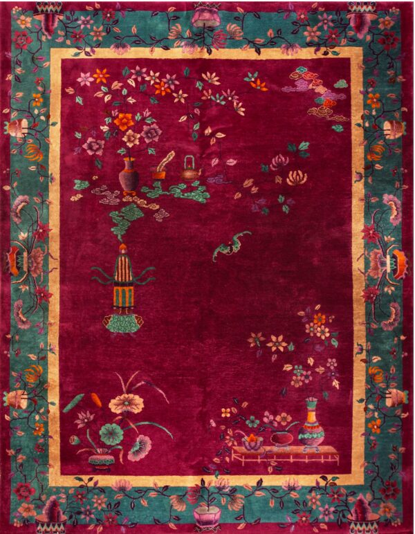 Oriental rug featuring a magenta field, teal floral borders, and detailed vases and botanical motifs.
